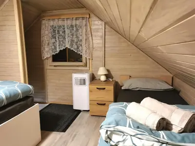 a small room with two beds and a refrigerator at Cosy Retreat Čatež in Čatež ob Savi