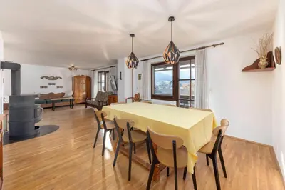 a dining room and living room with a table and chairs at Holiday Home Kersnik in Bohinj