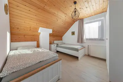 a bedroom with two beds and a wooden ceiling at Holiday Home Kersnik in Bohinj