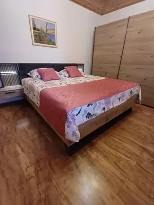 a large bed in a room with a wooden floor at Apartments Ivančič in Kobarid