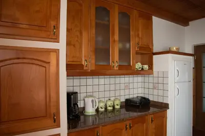 a kitchen with wooden cabinets and a counter top at Apartments Ivančič in Kobarid
