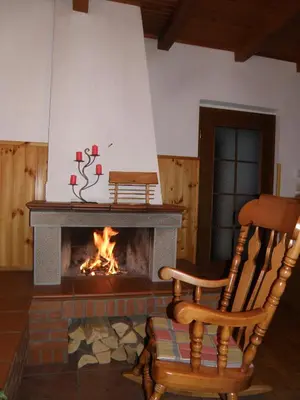 a fireplace with a rocking chair in front of it at Apartments Ivančič in Kobarid