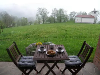 a wooden table with a plate of food and two chairs at Apartments Ivančič in Kobarid