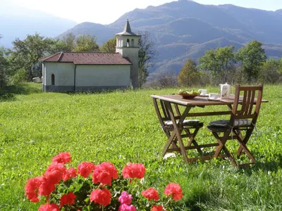 a table and chairs in a field with flowers at Apartments Ivančič in Kobarid