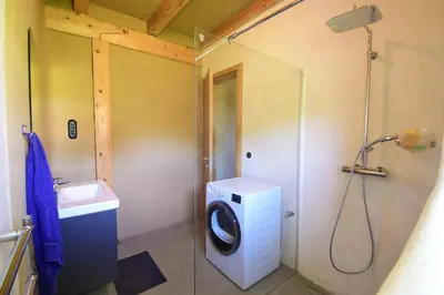 a bathroom with a washing machine and a washer at Hisa Vukan - Eco House in middle of vineyard with Sauna! in Miklavž pri Ormožu