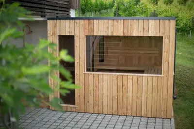 a wooden dog house with a window in a yard at Hisa Vukan - Eco House in middle of vineyard with Sauna! in Miklavž pri Ormožu