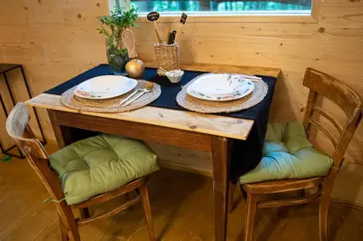 a wooden table with plates and bowls on it at Living Forest Resort in Moravske Toplice