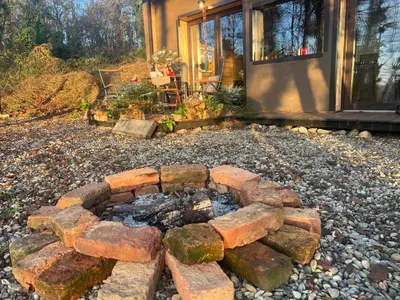 a brick fire pit in front of a house at Living Forest Resort in Moravske Toplice