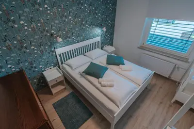a small bedroom with a bed with blue walls at APARTMA LAMBERGER in Žirovnica