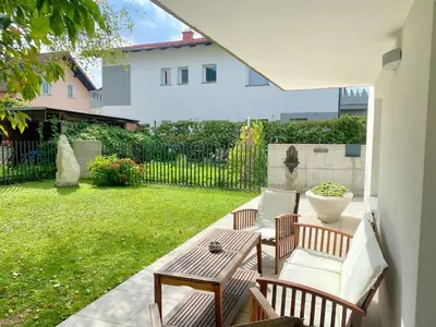 a patio with a table and chairs and a yard at Valetier apartments in Ljubljana
