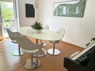 a white dining room table with chairs and a keyboard at Valetier apartments in Ljubljana