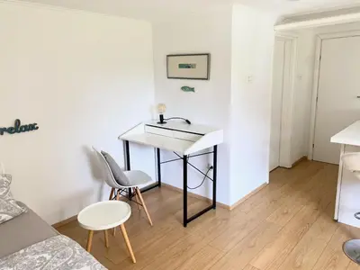 a small living room with a desk and chairs at Valetier apartments in Ljubljana