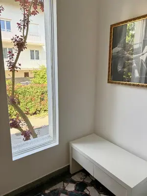 a white bench sitting next to a window at Valetier apartments in Ljubljana