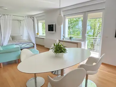 a living room with a white table and chairs at Valetier apartments in Ljubljana