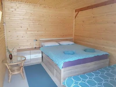 a bedroom with two beds and a table in it at Hiška Zeleni raj in Podnart