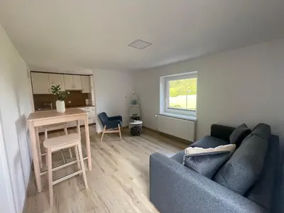 a living room with a blue couch and a table at The Boathouse Apartment in Bled