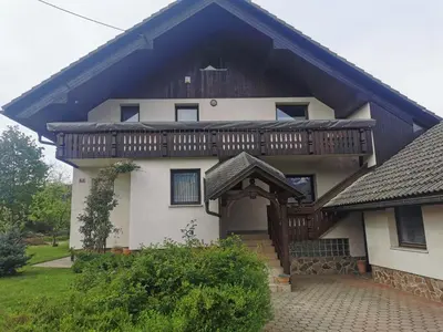 a house with a wooden roof and a porch at APARTMA MARUŠA in Bled