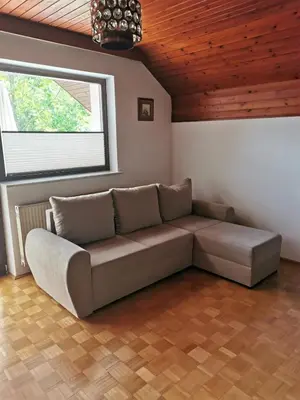 a couch in a living room with a window at APARTMA MARUŠA in Bled