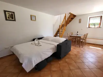 a bedroom with a bed and a table with chairs at Holiday Home Belka with Terrace&BBQ in Tolmin
