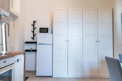 a kitchen with white cabinets and a refrigerator at Apartment TRG in Brežice