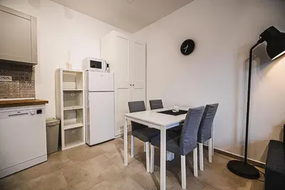 a kitchen with a table and chairs and a white refrigerator at Apartment TRG in Brežice
