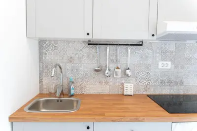 a kitchen with a sink and white cabinets at Apartment TRG in Brežice