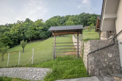 a building with a gate and a stone wall at Vineyard cottage Jelenov hrib in Smarjeske Toplice