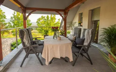 a patio with a table and chairs on a balcony at Vineyard cottage Jelenov hrib in Smarjeske Toplice