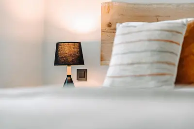 a lamp sitting on a bed next to a pillow at Goat's Paradise in Bohinj