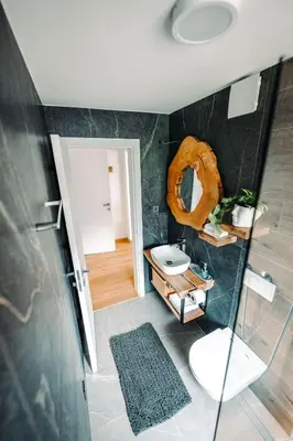 a bathroom with a toilet and a donut on the wall at Goat's Paradise in Bohinj