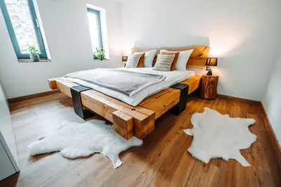 a bedroom with a bed and two rugs at Goat's Paradise in Bohinj