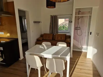 a white dining room table with white chairs and a couch at Holiday home Melisa in Mozirje