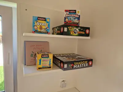a shelf with games and books on a wall at Holiday home Melisa in Mozirje