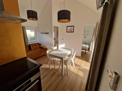 a kitchen and living room with a table and chairs at Holiday home Melisa in Mozirje