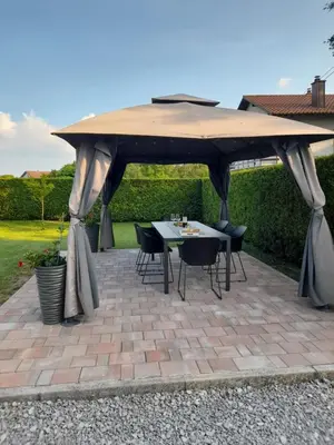 a picnic table under a large umbrella on a patio at Apartma Relax in Prestranek