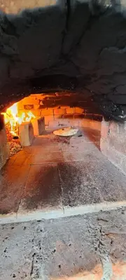 a brick oven with a pizza inside of it at Apartma Relax in Prestranek