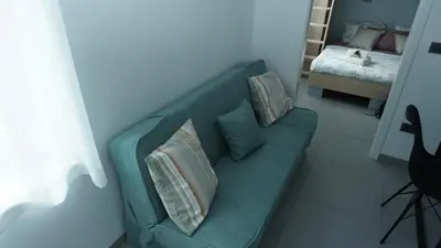 a green couch with pillows in a living room at Apartma Relax in Prestranek