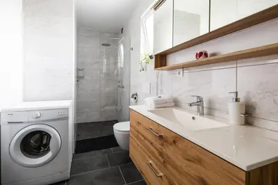 a bathroom with a sink and a washing machine at Vila Emina in Podčetrtek