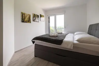 a bedroom with a large bed and a window at Vila Emina in Podčetrtek