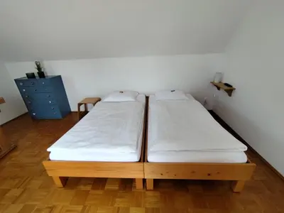 two twin beds in a room with wooden floors at MaLu apartment in nature with terrace in Jakovica