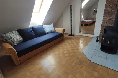 a living room with a blue couch and a staircase at MaLu apartment in nature with terrace in Jakovica