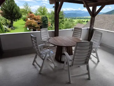 a table and chairs on a balcony with a view of a field at MaLu apartment in nature with terrace in Jakovica