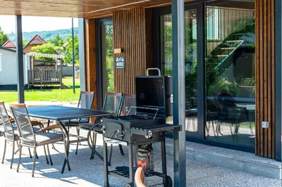 a patio with a table and chairs and a grill at ARIA DELUXE Mobile Homes with Terme Čatež Tickets in Čatež ob Savi