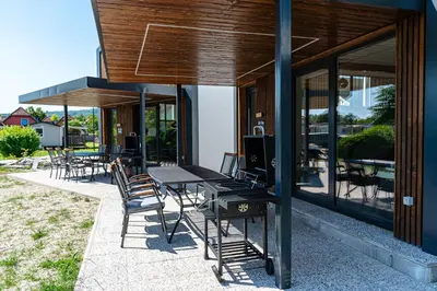 a group of tables and chairs on a patio at ARIA DELUXE Mobile Homes with Terme Čatež Tickets in Čatež ob Savi
