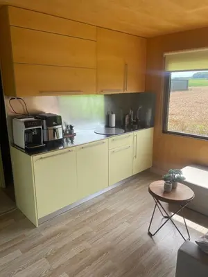 a kitchen with white cabinets and a window and a table at BIG BERRY Kolpa - Isabella Premium House in Gradac