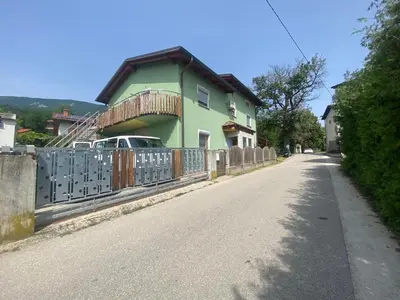 a house with a fence on the side of a road at Apartment GREEN HOUSE in Šempas