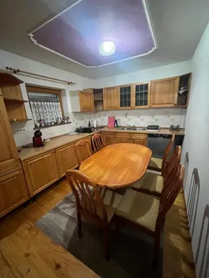 a kitchen with a wooden table and wooden cabinets at Apartment GREEN HOUSE in Šempas