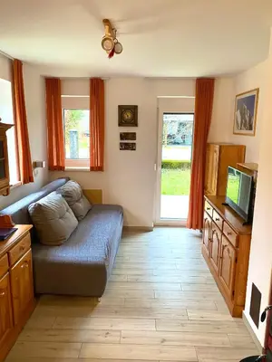 a living room with a couch and a television at Apartma EMI in Bovec