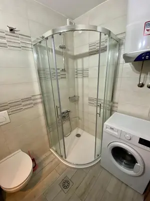a bathroom with a shower and a washing machine at Apartma EMI in Bovec