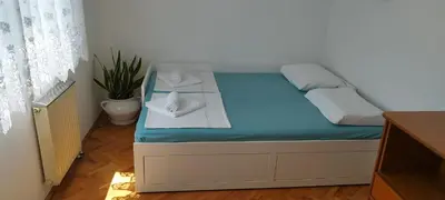 a small bed with two white towels on it at 7 Flower Street Apartment in Šempeter pri Gorici